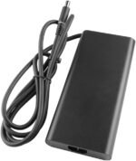 Black rectangular laptop power adapter with attached cord and DC barrel connector, coil nearby.