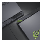 Close-up of a dark gray gaming laptop with neon green accents, shown at a diagonal angle.