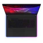 Top-down view of a black gaming laptop with a rainbow RGB keyboard, glowing border, and a colorful screen displaying ROG STRIX.