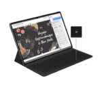 Tablet in a keyboard case on a stand, displaying a chalkboard-style slide reading 'Voyage Gastronomique à New York' with a weather panel, and a small black detachable accessory shown to the right.