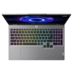 Open silver Lenovo laptop with a rainbow RGB keyboard and a glowing circular screen design overhead, showcasing a gaming/creative setup.