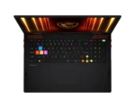 Top-down view of a black gaming laptop with a bright RGB keyboard and a fiery display graphic.