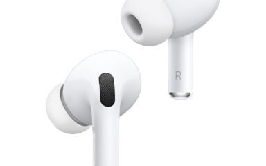 Close-up of white wireless earbuds with silicone tips and short stems, angled to show ear tips and outer speaker grills.