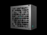Front view of a metal computer power supply with a square grid vent and visible cooling fan behind, on a black background.