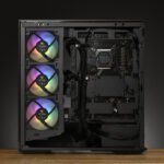 Interior of a black PC case showing three rainbow RGB intake fans on the left and a motherboard with the CPU socket on the right.
