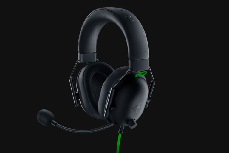 Black over-ear gaming headset with attached mic on a dark background, wired with a green accent cable (Razer branding). Popular for immersive audio.