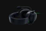 Black gaming headset with attached microphone and cushioned ear cups on a dark background, featuring subtle green accents and a matte finish on the headband and ear pads.