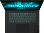 Open laptop seen from above, screen displays a neon blue 'GIGABYTE' logo with a teal backlit keyboard.